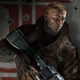 BJ standing with his back to a wall and holding a large machine gun, ready to fight.